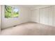 Bright bedroom features a large window with natural light and closet with bi-fold doors at 1129 Genesee Vista Rd, Golden, CO 80401