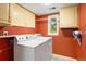 Functional laundry room with washer, dryer, storage cabinets and window with backyard view at 1129 Genesee Vista Rd, Golden, CO 80401