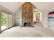 Spacious living room featuring a stone fireplace, walkout deck, and access to upper level at 1129 Genesee Vista Rd, Golden, CO 80401