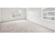 Neutral bedroom featuring carpet, base trim, and two windows at 27684 E Byers Ave, Aurora, CO 80018