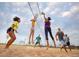 Friends playing volleyball on a sandy court with a net under a partly cloudy sky at 27684 E Byers Ave, Aurora, CO 80018