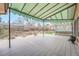 Large outdoor deck featuring a green canopy and a view of the backyard at 8095 E Lehigh Ave, Denver, CO 80237