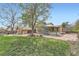Backyard features a spacious deck, lush lawn, stone patio, and mature trees at 8095 E Lehigh Ave, Denver, CO 80237
