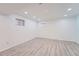 Basement with gray wood flooring and two windows letting in natural light at 8095 E Lehigh Ave, Denver, CO 80237
