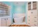 This primary bathroom features a standalone soaking tub, built-in cabinetry, and a glass block window at 8095 E Lehigh Ave, Denver, CO 80237