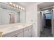 Bathroom featuring double sinks, white cabinets and a large mirror above the vanity at 8095 E Lehigh Ave, Denver, CO 80237