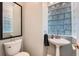 This bathroom features a pedestal sink, a glass block window, and a modern toilet at 8095 E Lehigh Ave, Denver, CO 80237