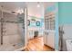 This primary bathroom features a glass shower, dual sinks, and wood floors at 8095 E Lehigh Ave, Denver, CO 80237