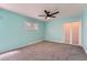 This bedroom features a ceiling fan, a window, sliding closet doors, and light blue walls at 8095 E Lehigh Ave, Denver, CO 80237