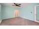 This bedroom features a ceiling fan, a window, sliding closet doors, and light blue walls at 8095 E Lehigh Ave, Denver, CO 80237