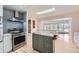 Bright kitchen featuring stainless steel appliances, an island, skylight, and modern backsplash at 8095 E Lehigh Ave, Denver, CO 80237