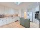 Modern kitchen featuring white cabinets, stainless steel appliances, and a kitchen island at 8095 E Lehigh Ave, Denver, CO 80237