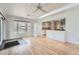 Open-concept room with hardwood floors, multiple windows, and an opening to the kitchen at 8095 E Lehigh Ave, Denver, CO 80237
