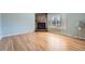 Bright living room with wood floors, a stone fireplace, and natural light from large windows at 8095 E Lehigh Ave, Denver, CO 80237