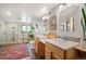 Bathroom featuring double sinks, glass shower, decorative tile, and lots of light at 2084 Bell Ct, Lakewood, CO 80215