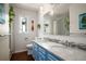Bright bathroom featuring a dual sink vanity with marble countertop and tiled shower at 2084 Bell Ct, Lakewood, CO 80215