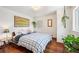 A cozy bedroom featuring hardwood floors, a patterned blanket, and ample natural light at 2084 Bell Ct, Lakewood, CO 80215