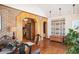 Dining room with an arched entrance to the kitchen, hardwood floors, and a brick accent wall at 2084 Bell Ct, Lakewood, CO 80215