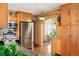 Bright kitchen featuring stainless steel appliances, wood cabinets, and an open doorway to a sunroom at 2084 Bell Ct, Lakewood, CO 80215
