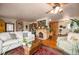 Cozy living room with brick fireplace, wood floors, comfortable seating, and ceiling fan with light fixture at 2084 Bell Ct, Lakewood, CO 80215