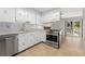 Bright kitchen with white cabinets and stainless steel appliances next to a sliding glass door at 2960 S Parker Ct, Aurora, CO 80014