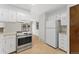 Kitchen with white appliances and cabinetry and an open floor plan that leads to the dining area at 2960 S Parker Ct, Aurora, CO 80014