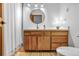Bright bathroom features a wood vanity with white countertop, round mirror, and a shower with curtain at 23646 Genesee Village Rd, Golden, CO 80401