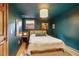 Serene bedroom features teal walls, complemented by a queen bed and soft lighting, a tranquil retreat at 23646 Genesee Village Rd, Golden, CO 80401