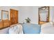 Bedroom featuring light blue comforter and decorative dresser with attached mirror, adding a vintage touch at 23646 Genesee Village Rd, Golden, CO 80401