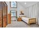 Bright bedroom with a vaulted ceiling, a cozy bed, and ample natural light from the expansive windows at 23646 Genesee Village Rd, Golden, CO 80401
