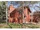 Beautiful home featuring wood siding, large windows, and mature trees surrounding the property at 23646 Genesee Village Rd, Golden, CO 80401