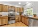 Modern kitchen featuring stainless steel appliances, butcher block countertops, and a window with natural light at 23646 Genesee Village Rd, Golden, CO 80401