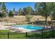 Community pool with plenty of lounge chairs, surrounded by trees and well-maintained grounds at 23646 Genesee Village Rd, Golden, CO 80401