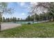 Community tennis court surrounded by mature trees, providing a serene recreational space at 23646 Genesee Village Rd, Golden, CO 80401