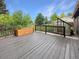Wooden back deck featuring a small greenhouse, flower planters, and a fenced garden beyond at 9236 W Euclid Ave, Littleton, CO 80123