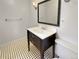 Stylish bathroom featuring a modern vanity, sleek fixtures, and classic black and white tiled floors at 9236 W Euclid Ave, Littleton, CO 80123