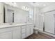 Modern bathroom with dual sinks, sleek white cabinets, and a glass-enclosed shower at 6974 E 126Th Dr, Thornton, CO 80602