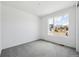 Bright bedroom with plush gray carpet and a large window offering neighborhood views at 6974 E 126Th Dr, Thornton, CO 80602