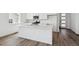 Open-concept kitchen featuring a large center island, modern white cabinets and stainless appliances at 6974 E 126Th Dr, Thornton, CO 80602