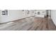 Bright, open-concept living space with modern white kitchen and sleek wood flooring at 6974 E 126Th Dr, Thornton, CO 80602