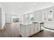 Bright and open floor plan with sleek wood flooring, a kitchen island, and modern finishes at 6974 E 126Th Dr, Thornton, CO 80602