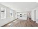 Bright, open-concept living space with modern white kitchen and sleek wood flooring at 6974 E 126Th Dr, Thornton, CO 80602