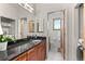Bathroom featuring dual mirrors, wood cabinets, and laundry room access at 350 Holly St, Denver, CO 80220