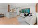Open living space with bar seating, pendant lights, and a stylish white curved sofa at 350 Holly St, Denver, CO 80220