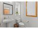 Elegant half-bathroom featuring a pedestal sink, decorative mirror, and minimalist design at 350 Holly St, Denver, CO 80220