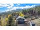 Beautiful aerial view of a home surrounded by lush greenery and stunning mountain scenery at 779 Aspen Way, Evergreen, CO 80439