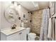 Bathroom with beige walls, stone shower, updated vanity, and decorative mirror and art at 779 Aspen Way, Evergreen, CO 80439