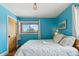 Bedroom showcasing hardwood floors, blue walls, and a cozy sleeping space at 779 Aspen Way, Evergreen, CO 80439