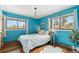 Bedroom with hardwood floors, blue walls, two large windows, and updated decor at 779 Aspen Way, Evergreen, CO 80439