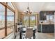 Bright dining area with large windows providing scenic views, a modern chandelier, and access to the outdoors at 779 Aspen Way, Evergreen, CO 80439
